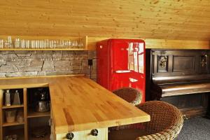 Habitación con mesa de madera y nevera roja. en Chata Ryba, en Pernink