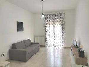 ein Wohnzimmer mit einem Sofa und einem TV in der Unterkunft Casa di Aisha in Santa Maria Capua Vetere