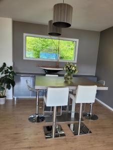 une salle à manger avec une table et des chaises blanches dans l'établissement Beautiful property in front of Annecy Lake, à Veyrier-du-Lac