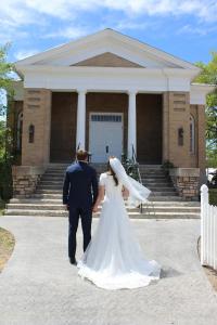 a bride and groom walking in front of a building at The Gathering Place in Salina