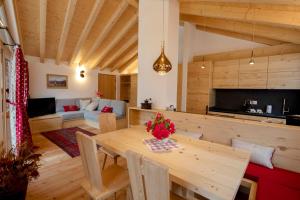 cocina y sala de estar con mesa de madera en Chalet del Capriolo, en Vodo Cadore