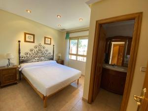 ein Schlafzimmer mit einem Bett und ein Badezimmer mit einer Badewanne in der Unterkunft GranPlaya in Santa Pola