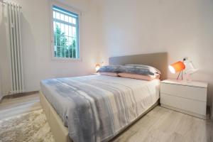 ボローニャにあるGhisello Luxury Guesthouse 1のベッドと窓のある白い寝室