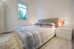 una camera bianca con un letto e una finestra di Ghisello Luxury Guesthouse a Bologna