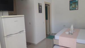 een witte kamer met een koelkast en een bank bij Vila Juna in Ksamil +80 foto's