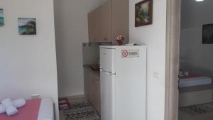 een kleine keuken met een koelkast in de kamer bij Vila Juna in Ksamil