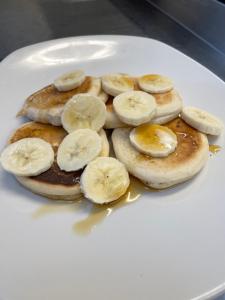 a white plate with pancakes with bananas on them at The Mey Hotel in Mey