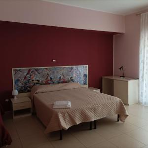 a bedroom with a bed with a painting on the wall at Il Fiore di San Giovanni B&B in Milazzo