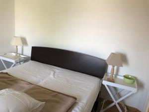 1 dormitorio con 1 cama y 2 mesas con lámparas en Camélia rouge en Granville