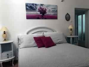 1 dormitorio con 1 cama y una pintura en la pared en da Annamaré, en Montalbano