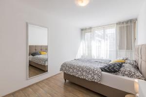 biała sypialnia z łóżkiem i lustrem w obiekcie Sunny City Apartment w Splicie