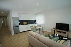 a living room with a couch and a table and a kitchen at GALIHOST - A Casa de Lena - Apartamentos Turísticos in Ribadumia