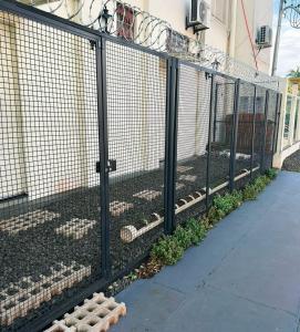 a fence with plants in it next to a building at Espaço Orla Morena in Campo Grande