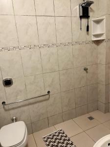 a bathroom with a toilet and a shower stall at Pousada AM PM in Campo Grande