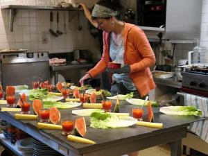 Uma mulher na cozinha a preparar comida. em Val d Azur B C em Molines-en-Queyras
