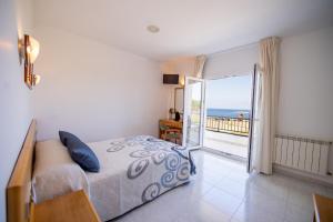um quarto com uma cama e vista para o oceano em Hotel Paraimo em A Lanzada