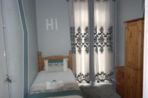 a small bedroom with a bed and curtains at Cavendish House Hotel in Great Yarmouth