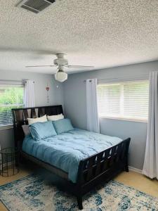 a bedroom with a bed with blue sheets and a ceiling at Cush Jax Baymeadows Ranch, Close to Everything! in Jacksonville