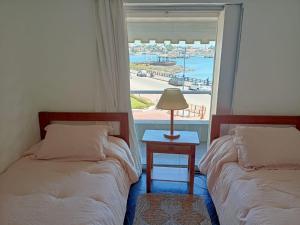 1 dormitorio con 2 camas y ventana con vistas en El Remanso - Suite 104, en Punta del Este