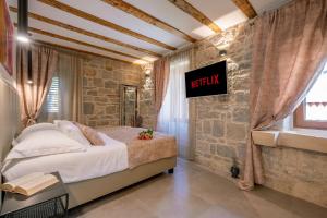 a bedroom with a bed in a brick wall at Old Spalatrum Luxury Rooms in Split