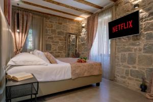 a bedroom with a bed and a sign on the wall at Old Spalatrum Luxury Rooms in Split