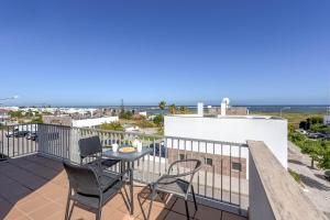 een balkon met een tafel en stoelen en de oceaan bij Penthouse Quilha in Fuzeta