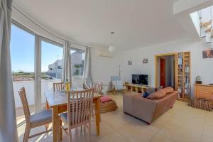 een woonkamer met een tafel en een bank bij Penthouse Quilha in Fuzeta