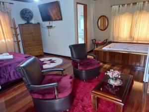 a living room with two chairs and a tub at Sítio Recanto do Araçá in Visconde De Maua