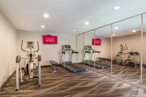 a gym with treadmills and ellipticals and mirrors at Red Roof Inn Dahlgren - Naval Base in Dahlgren