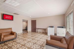 a waiting room with two leather chairs and a table at Red Roof Inn Dahlgren - Naval Base in Dahlgren