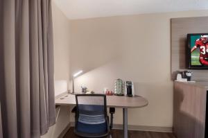 a room with a desk and a table with a chair at Red Roof Inn Dahlgren - Naval Base in Dahlgren