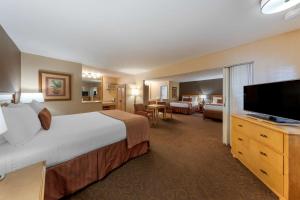 a hotel room with a large bed and a flat screen tv at Best Western Plus Pavilions in Anaheim