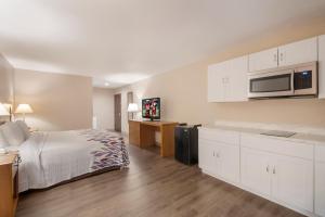 a hotel room with a bed and a microwave at Red Roof Inn Dahlgren - Naval Base in Dahlgren