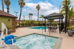 a pool at a resort with a table and chairs at Best Western Plus Pavilions in Anaheim