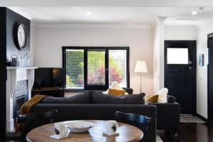 una sala de estar con un sofá y una mesa en Cricklewood- 2 bedroom enchanting miner's cottage, en Daylesford