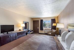 a hotel room with a bed and a flat screen tv at SureStay Hotel by Best Western Summersville in Summersville