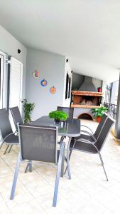 une salle à manger avec une table, des chaises et une cheminée dans l'établissement Anastasiou Home in central crossroad, à Perdika
