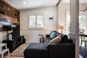 a living room with a couch and a tv at Table Hill Cottage in Daylesford