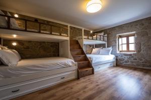 a bedroom with two bunk beds and wooden floors at Douro Senses - Nature House in Cinfães +22 photos