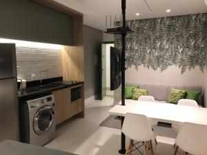 a kitchen with a washing machine and a table and chairs at Itaim Star Stay - Parque do Povo e Ibira Pertissimo! in Sao Paulo