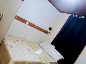 um pequeno quarto com uma cama e uma cortina azul em RESIDENCIAL OLIVEIRA em Manaus