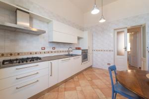 una cucina con armadi bianchi e tavolo in legno di Seaview Alghero Apt ad Alghero