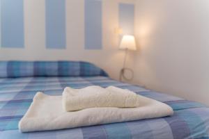 un asciugamano bianco seduto sopra un letto di Seaview Alghero Apt ad Alghero