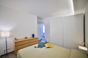 a bedroom with a bed with a yellow hat on it at Casa Blanca Sea View in Marina di Ragusa +3 photos