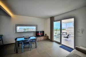 a living room with a table and a view of the ocean at Casa Blanca Sea View in Marina di Ragusa