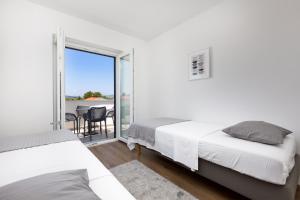 a bedroom with two beds and a balcony at Apartments Cukar in Punat