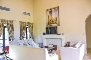 a living room with two white chairs and a fireplace at My Ozone Pool Villa KhaoYai in Pak Chong