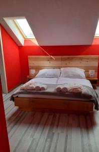 a bedroom with a large bed with a red wall at Mirocki-Raj in Miroč