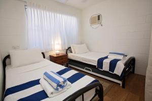 2 camas en una habitación pequeña con ventana en Apollo Jewel Beachfront Apartments, en South Mission Beach