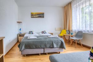 a bedroom with a bed and a table and a yellow chair at Ośrodek Wypoczynkowy CHAMPION in Władysławowo